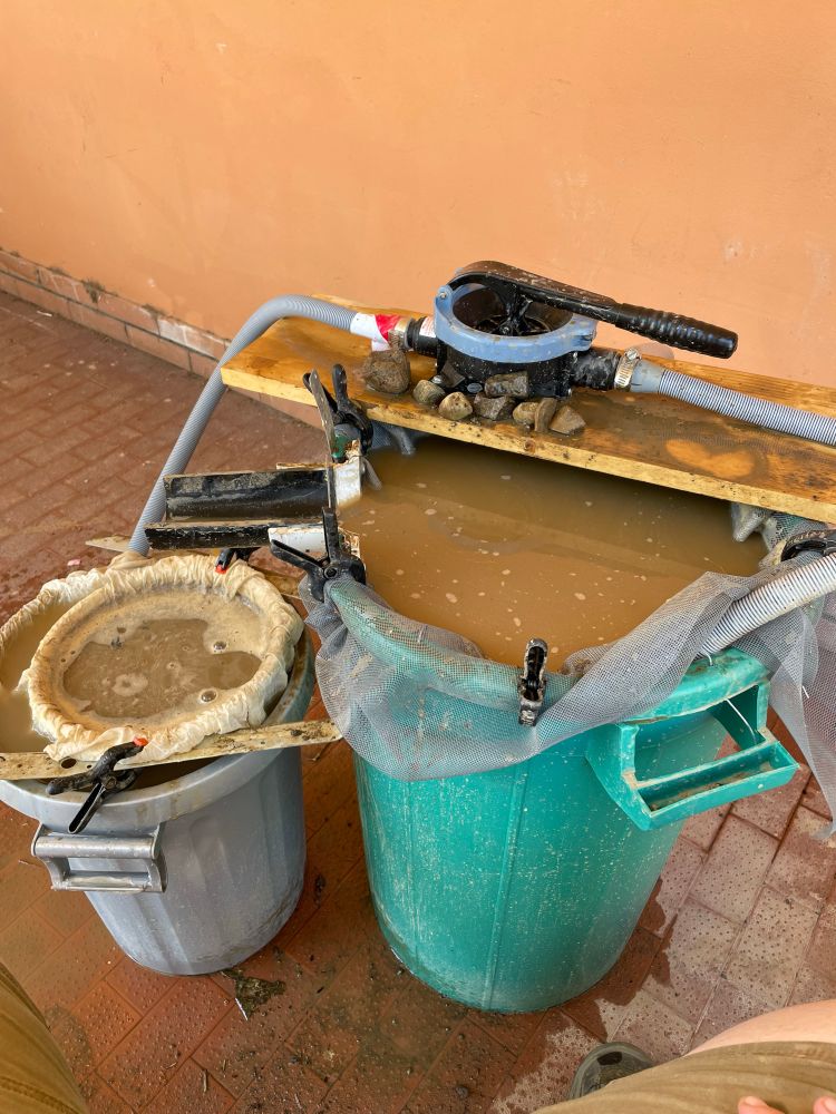 Photo of a flotation tank setup with two trash cans and a bilge pump. 