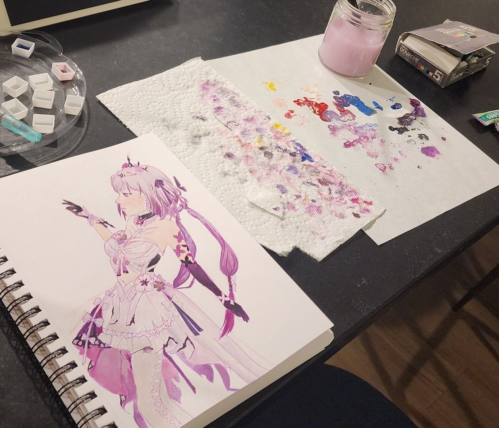 A picture of a sketchbook with a painting of castorice from honkai: star rail. Next to it is a paper towel smudged with purples and palette paper with various colors, and a jar of purple-white water with brushes in it.