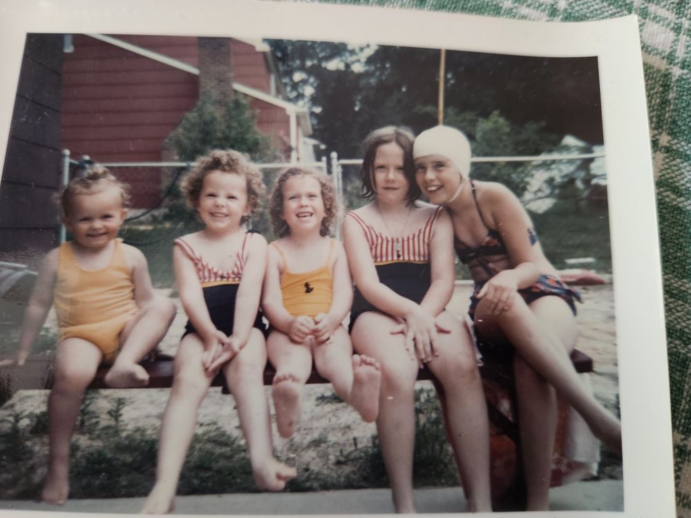 Bathing beauties!
5 girls in the early 1970s
Me (far left, yellow bathing suit over a diaper, brown/blonde hair that someone tried to putlll back but it's so short is just kinda sits atop my skull)
Cousin Tricia (looks like me but 3 years older and in a blue suit with red/white strip detail at the top)
Sister Shannon (looks nothing like me but has a matching yellow suit)
Cousin Barbara (matches Tricia's suit but has straight hair and no smile)
Cousin Janice (oldest of the cousins, wearing a white swim cap and a very daring bikini)