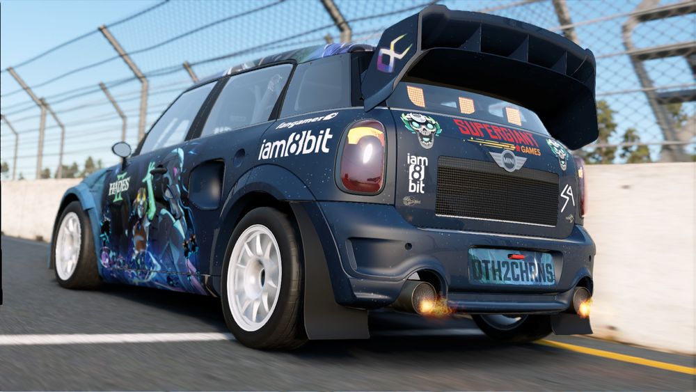 A rallycross MINI Countryman car with a custom made livery for the video game Hades II's 1.0 release on September 25th.
Predominantly using dark blue for the night sky and light blue color for mountains on the livery. Hades II, iam8bit, fangamer and Supergiant Games logos used throughout. With the game's artwork used throughout the sides, hood and roof of the car. And with a Supergiant Games' logo at the top of the car's boot/trunk. License plate on the back of the car spelling out Death To Chronos as DTH2CHRNS, one of the game's music tracks. Flames coming out of the car's exhaust pipes at the back.
This shot is set from behind the car so the left side and back are visible.
The side of the car has artwork of the game's protagonist Melinoe wielding a staff and her mentor Schelemeus looking on wistfully in the background. With iam8bit and fangamer logos above the rear wheels.