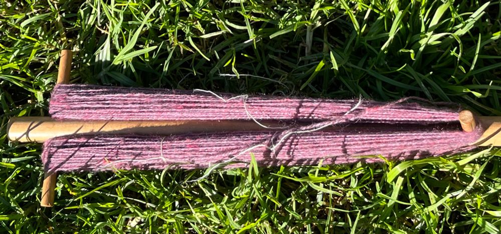 Not terribly good photo of spun pink batt on a noddy-noddy. It's been photographed in bright sun on the grass.