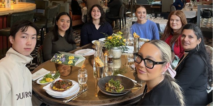 A group sit around a table enjoying dinner