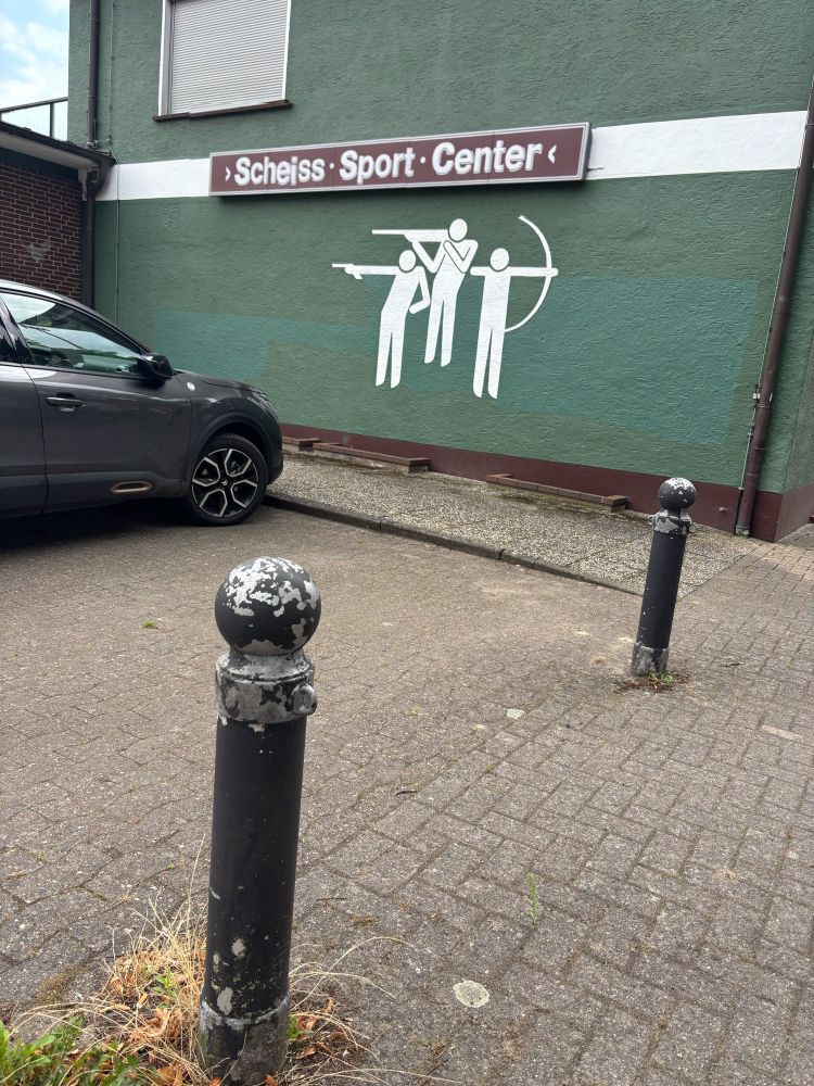 Man sieht das Geschäft von außen. Der Schriftzug wurde manipuliert. Das I und das E wurden vertauscht. Nun steht dort Scheiß – Sport – Center.
