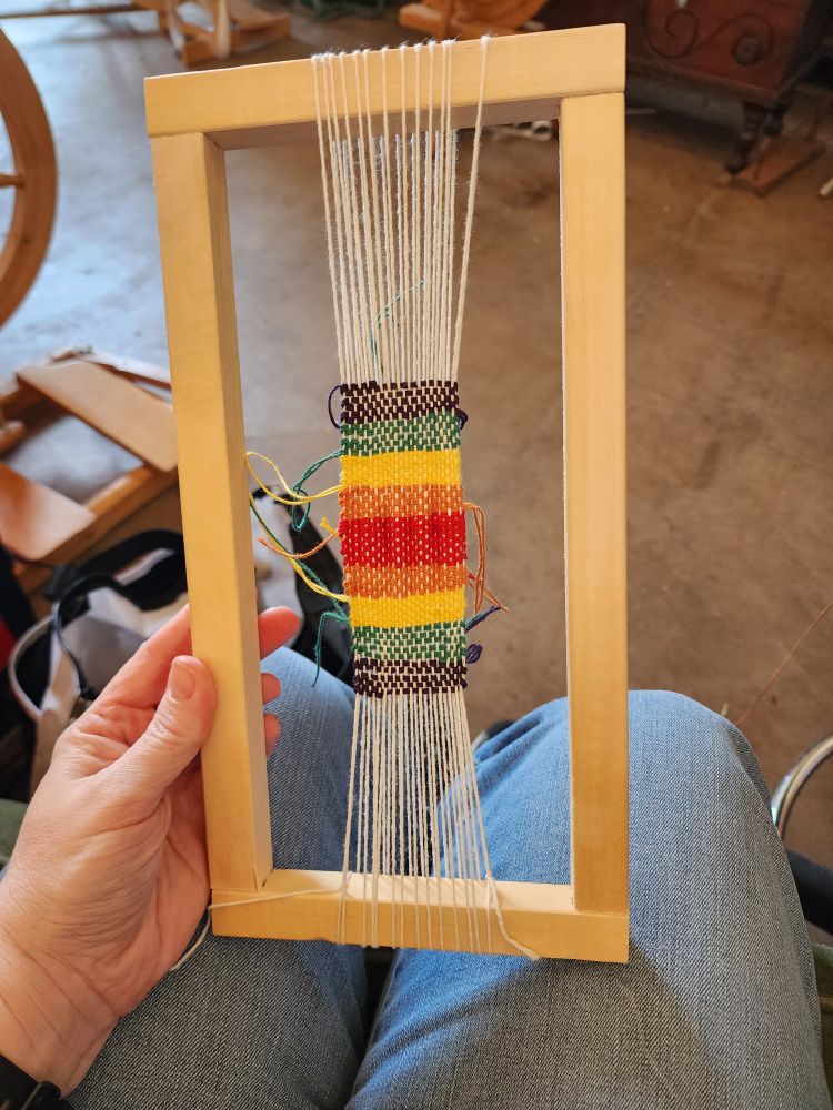 Rainbow-ish blanket on a frame loom. The red in the middle is puckered because I didn't pull as tightly on the yarn.
