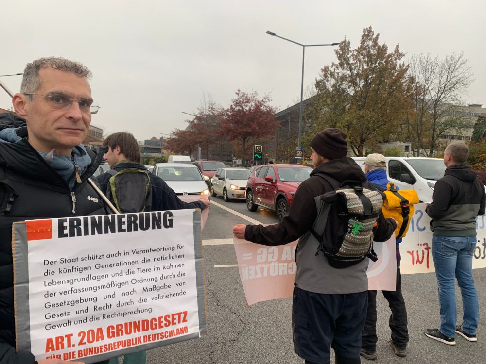 Menschen blockieren den Fritz-Foerster-Platz in Dresden. Sie halten Banner zur Erinnerung an Artikel 20a des Grundgesetztes: Schutz der natürlichen Lebensgrundlagen.