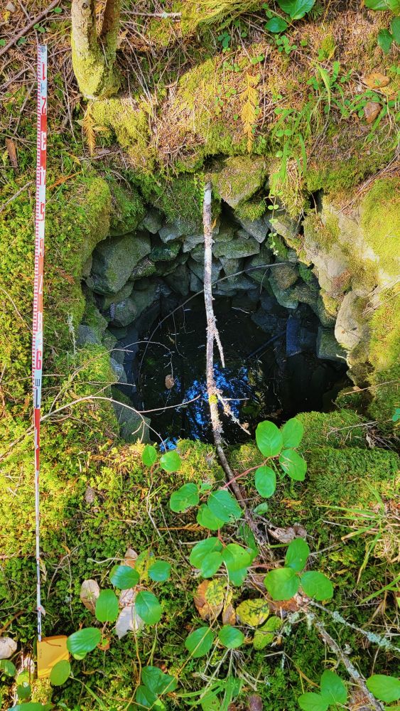 Looking down at a well with stacked stone circular walls