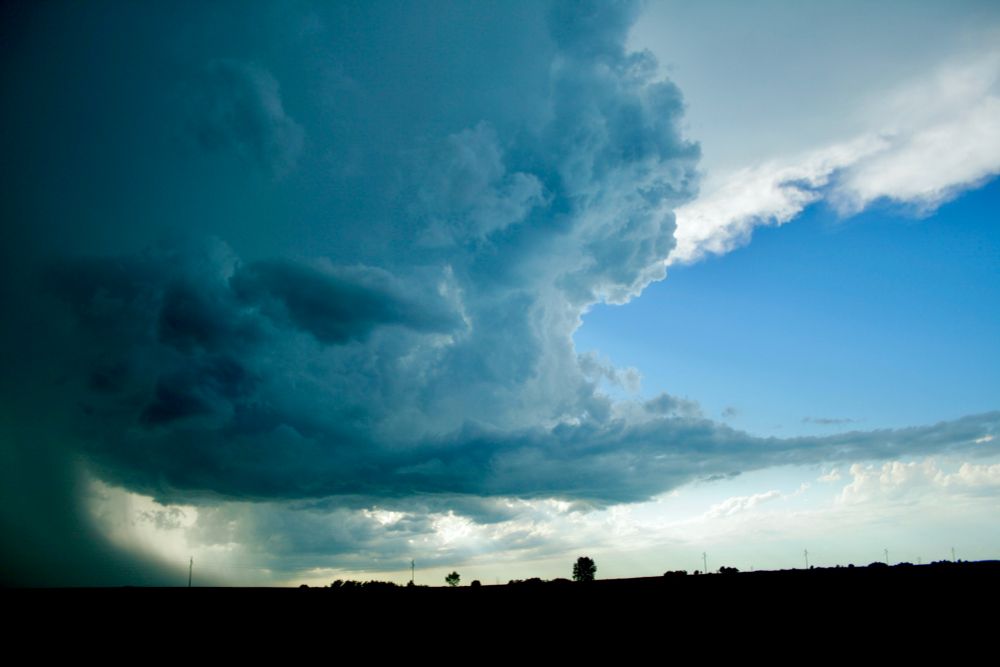 A photo of a they leading edge of a thunderhead over the Midwest plains at dusk. 