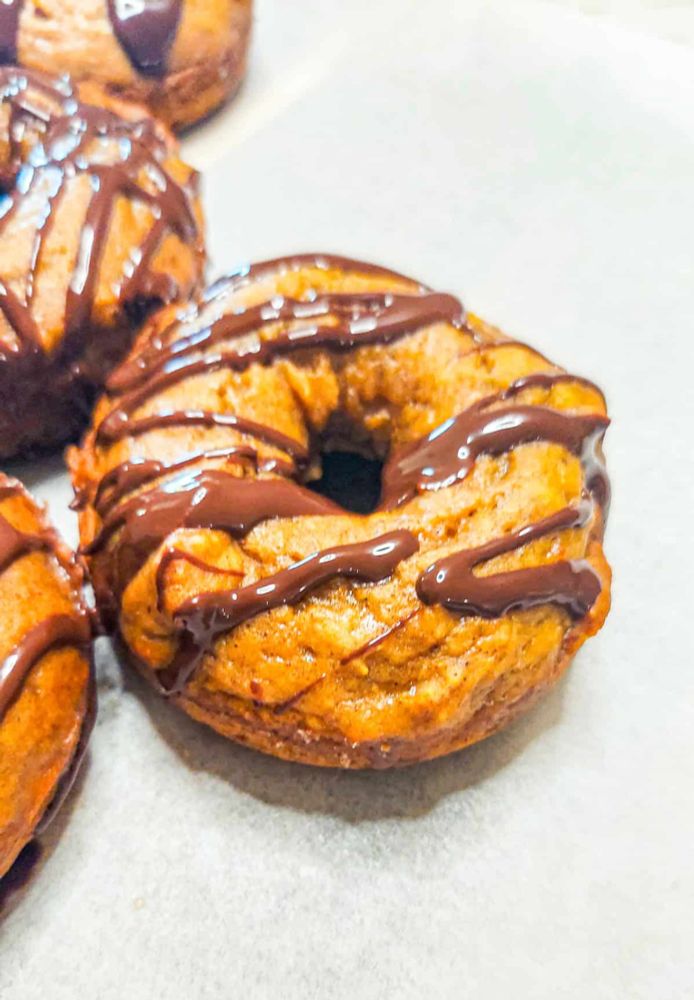 Pumpkin Spice Donuts with Maple Glaze and Chocolate Drizzle