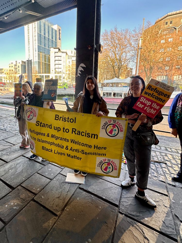 People stood with a stand up to racism banner 