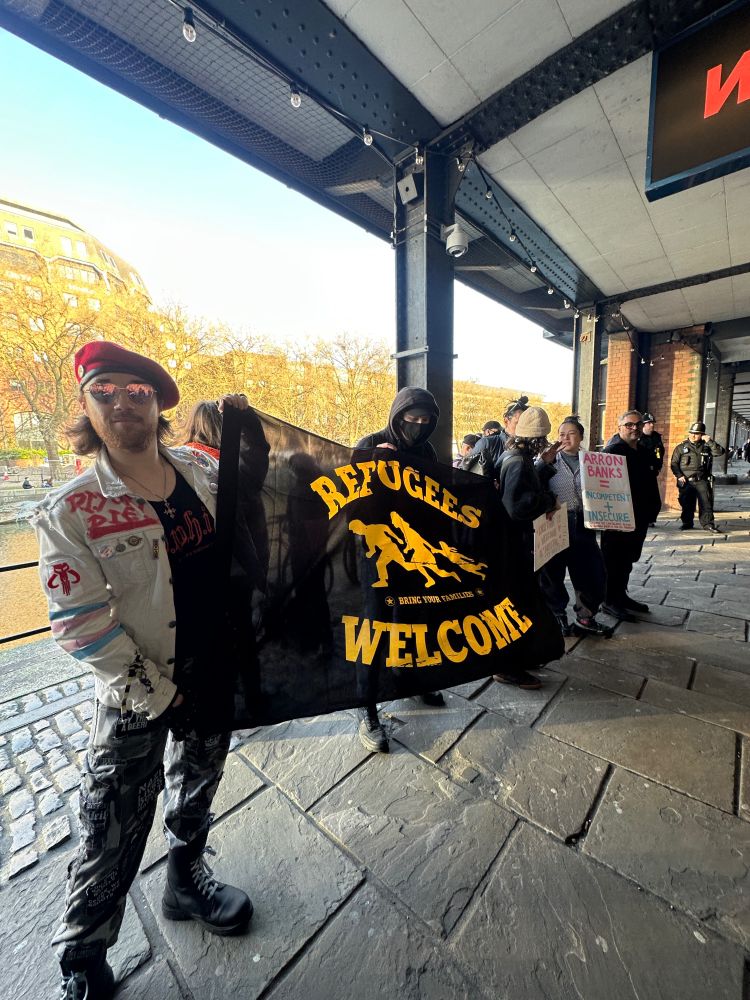 People stood with a refugees welcome banner 