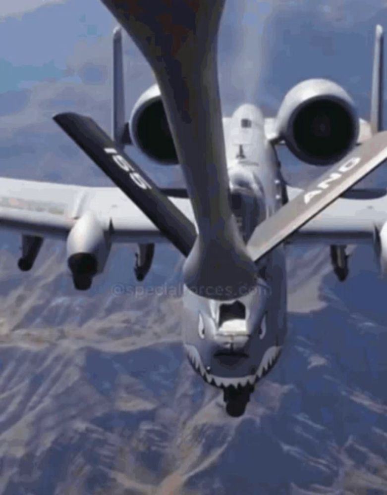 an a-10 fighter jet is being refuelled by another fighter jet