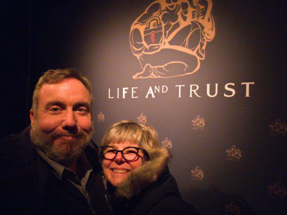 Josh & Marcy in front of a Life & Trust banner, smiling with gleeful anticipation. We had no idea what we'd be in for! 