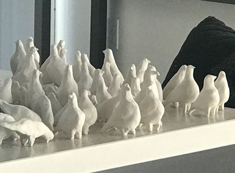 shelf of bisque-fired small white birds before they are glazed.