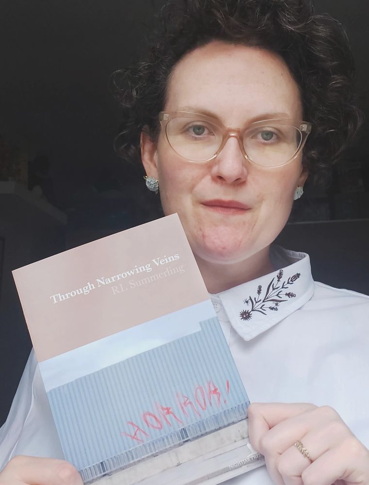 Rebecca holding a copy of her new chapbook 