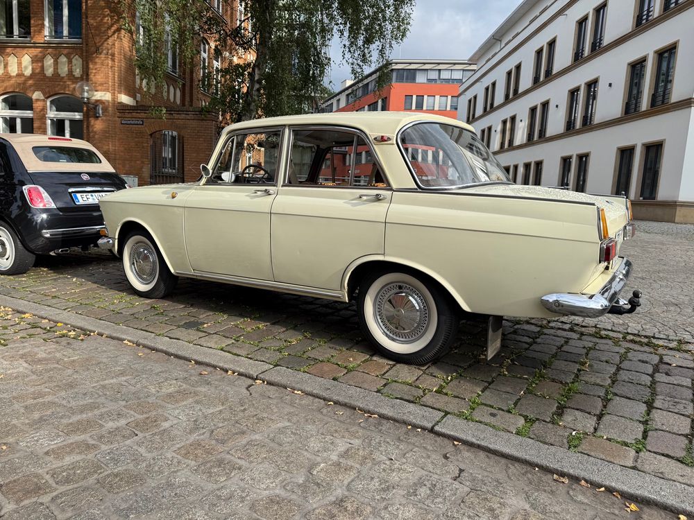 Seitenansicht eines am Straßenrand geparkten Autos der Marke Moskwitsch mit Weißwandreifen.