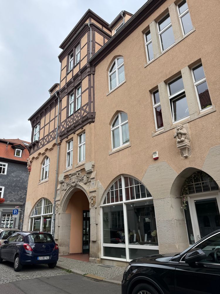 Gebäudeensemble aus zwei älteren Gebäuden. Die Fassade zieren ein sitzender steinerner Affe, an der Hausecke eine ebenfalls sitzende menschliche Figur. Das Tor zum vierstöckigen Haus, das in gelber Farbe daherkommt und im oberen Bereich in Fachwerk ausgeführt ist, schmückt ein aufwändig gestaltetes steinernes