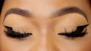 a close up of a person with large lashes and winged eyeliner