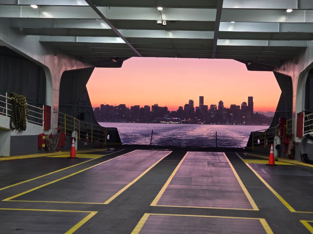 Picture of the Seattle city skyline at sunrise framed by the ferry.
