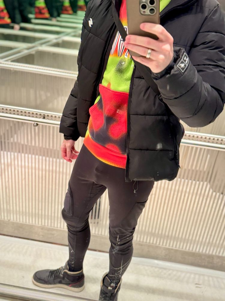 Picture in front of a mirror.
Outfit: black tights, colorful sweater. Chastity cage visible.