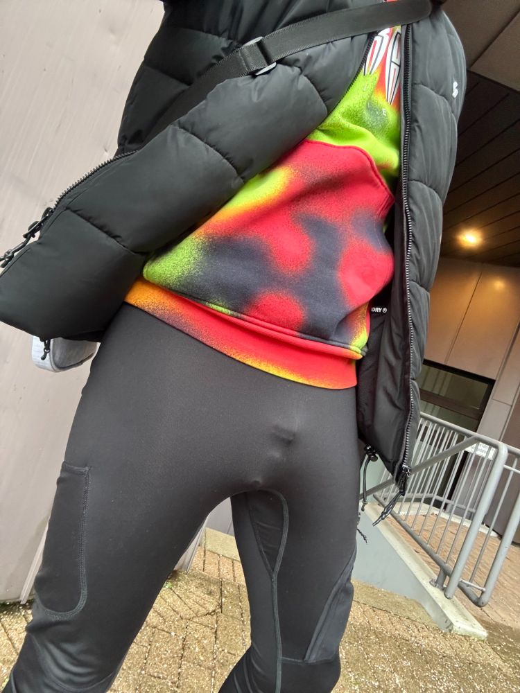 Outfit: black tights, colorful sweater. Chastity cage visible.