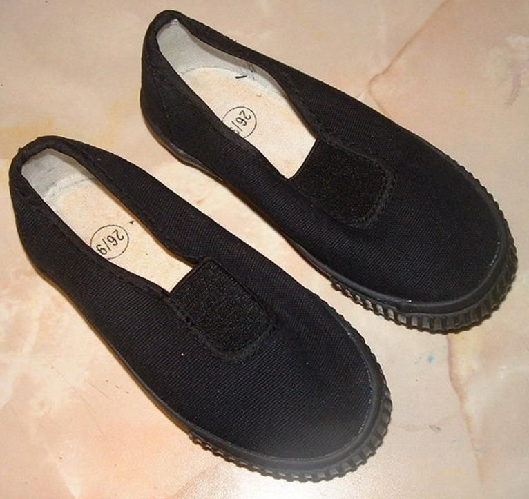 A pair of black school plimsolls.