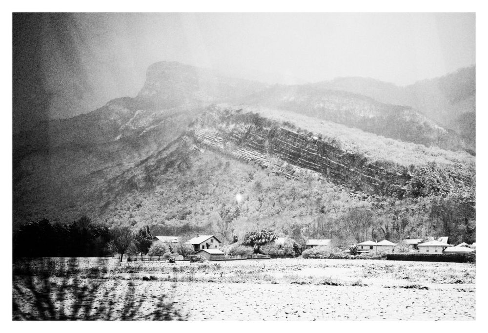 Plaine, maisons et contreforts de la Chartreuse sous la neige.