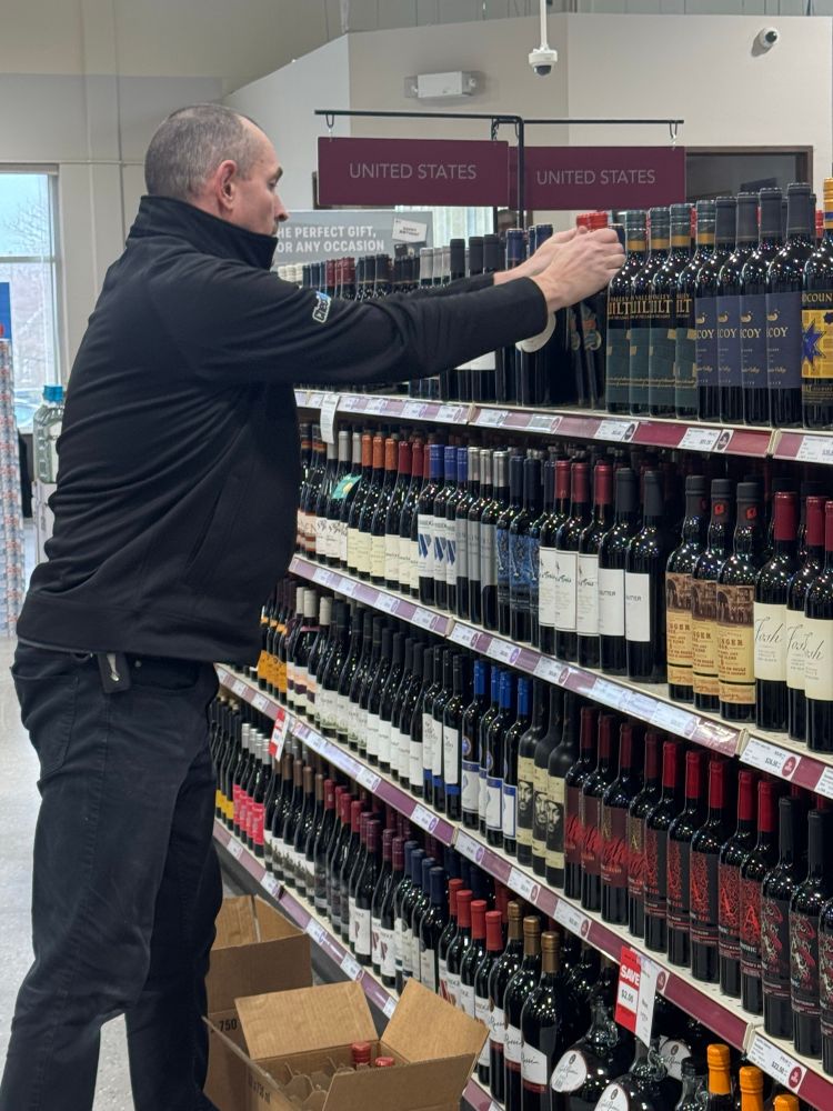 An NLC employee removing U.S. wine from the store shelf
