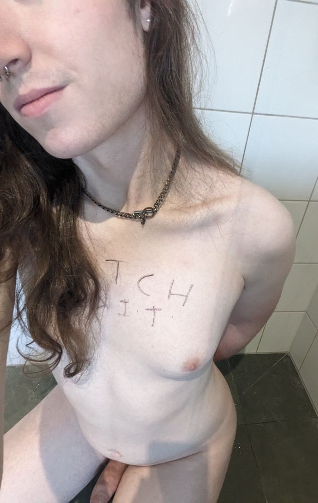 Alex naked on their knees in a shower with "butch bait" written across its chest.