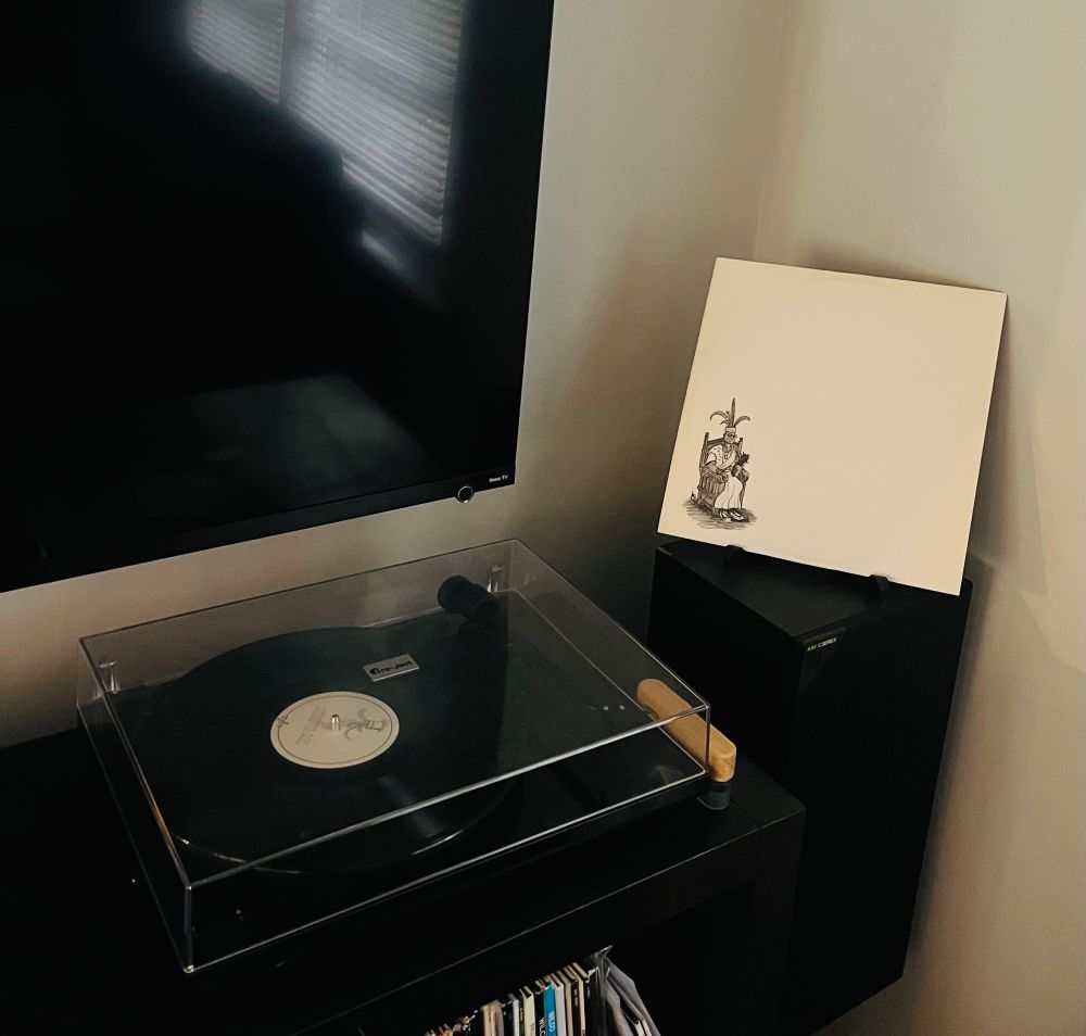 The album cover (front side). No text, white background, illustration of a kingly figure seated on a throne in black & white. On the back side there is similar artwork of a different kingly figure.