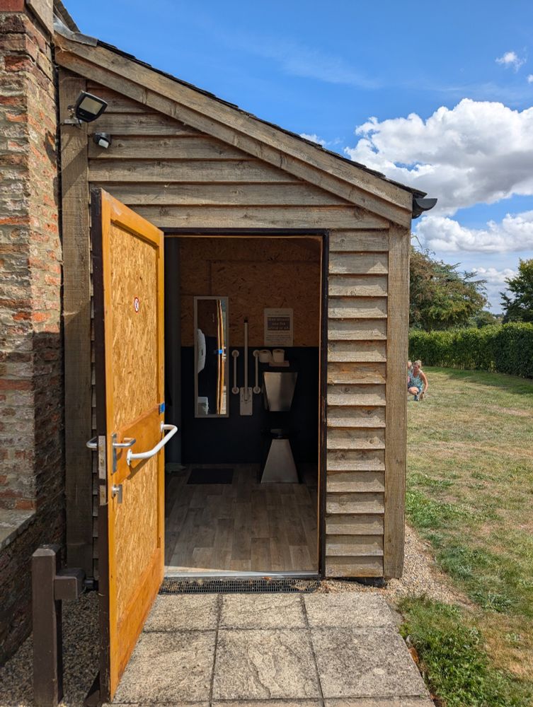 Wooden building, door open, compost toilet inside