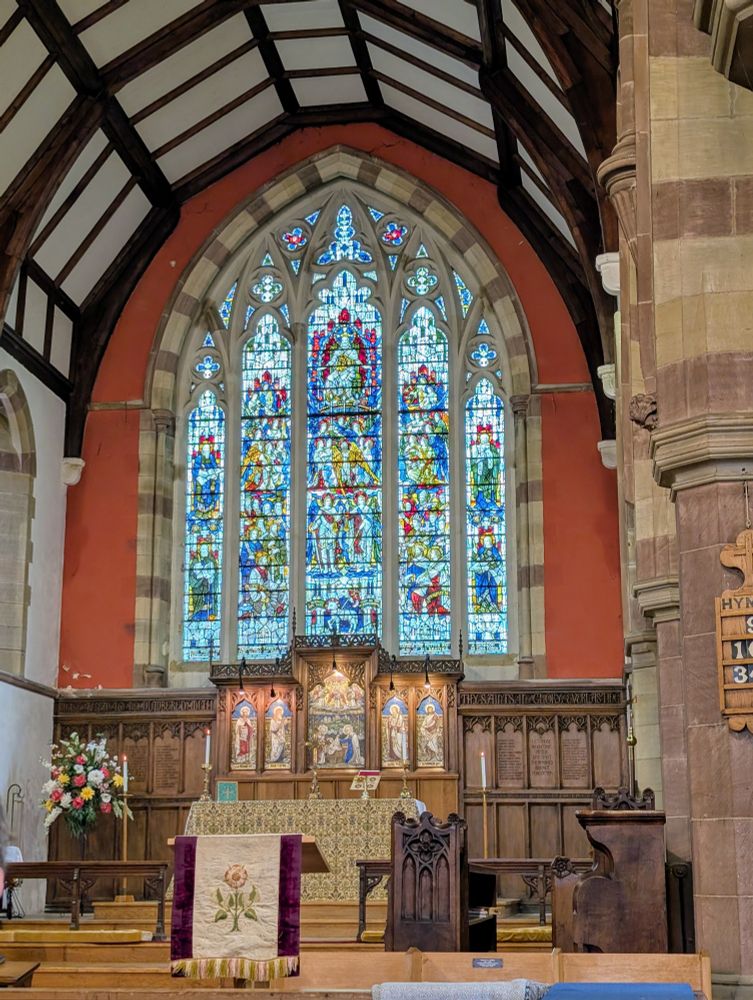Large stained glass window at the east end of the church, altar in front