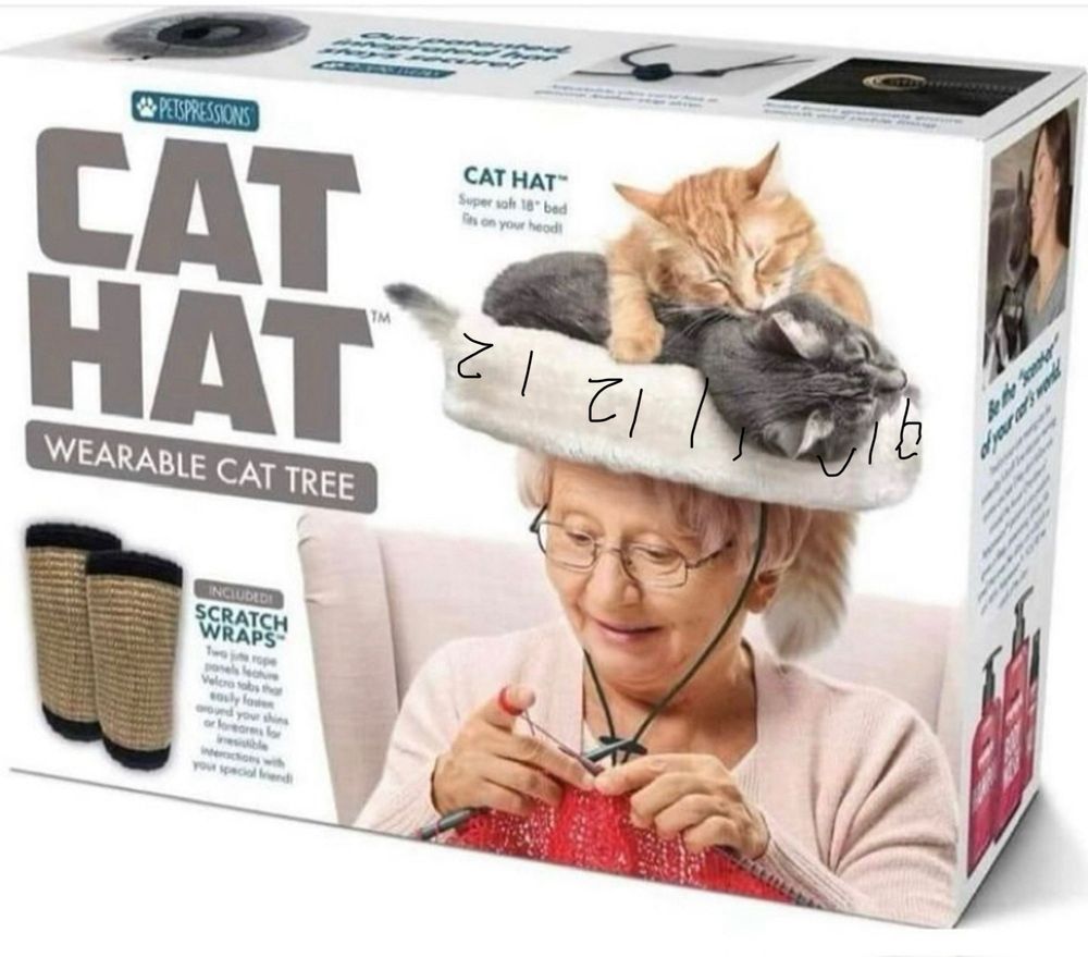 a photo of the Cat Hat Wearable Cat Tree product box by Petspressions. It displays two included Scratch Wraps on the left side below the product name. on the right side of the front of the box is a delightfully geriatric woman in a grandma-pink cardigan sitting in a high-backed chair knitting or crocheting something red, perched upon her head is The Cat Hat, complete with a pair of cats either sleeping or mid-wrastling in the Hat. the Hat is essentially a cat bed sombrero with a more rigid outer wall. around that wall, of course, are clock digits, encircling the hat so we see 12 o’clock in the very front. the clock is oriented on the Hat for the cats to check the time, so it is upside down for any outside viewer.