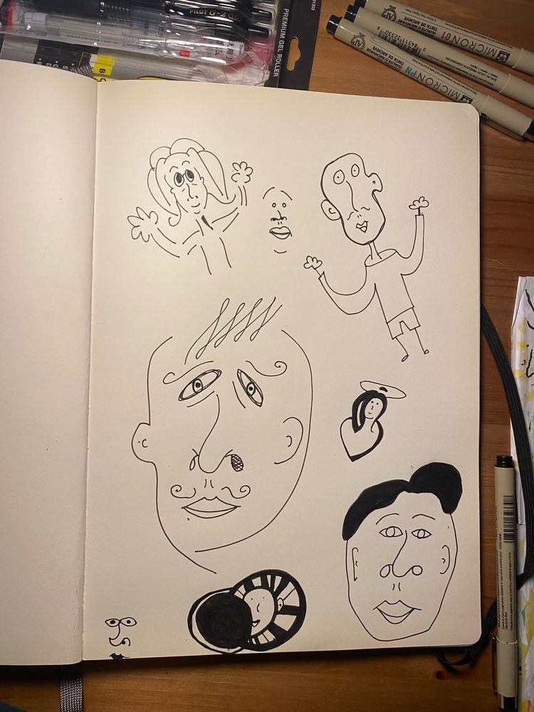 Page from a sketchbook of strange faces and characters drawn in ink. 