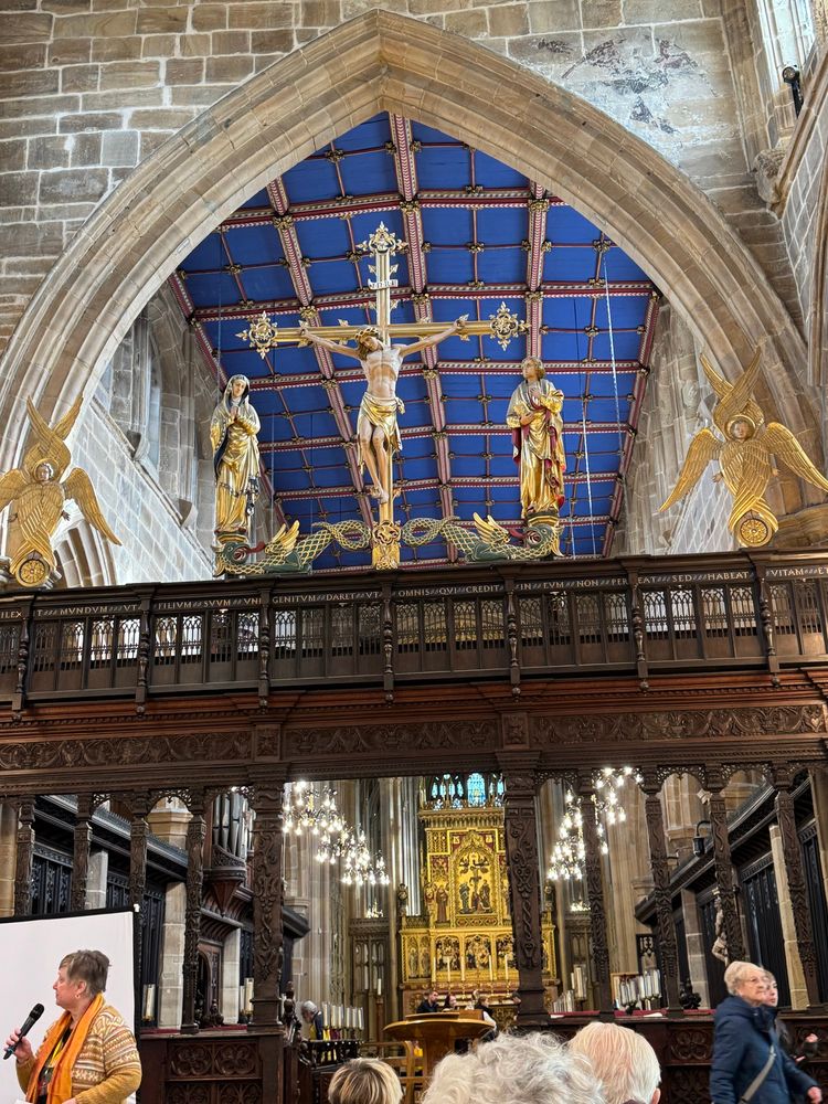 Crucifix flanked by Mary Mother of God on the left and a bespectacled St. John the Evangelist on the right. Mary and John stand on twining serpents. Cherubim guard the further corners.