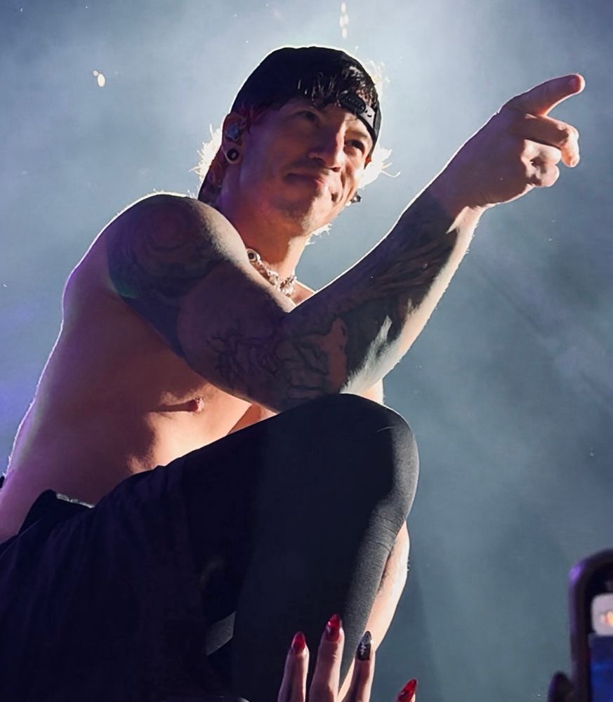 josh dun pointing to the right and kinda smiling