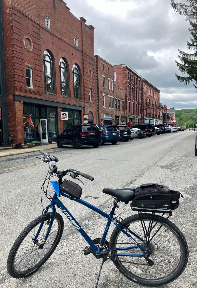 Blue bicycle on a street with old red brick buildings. 