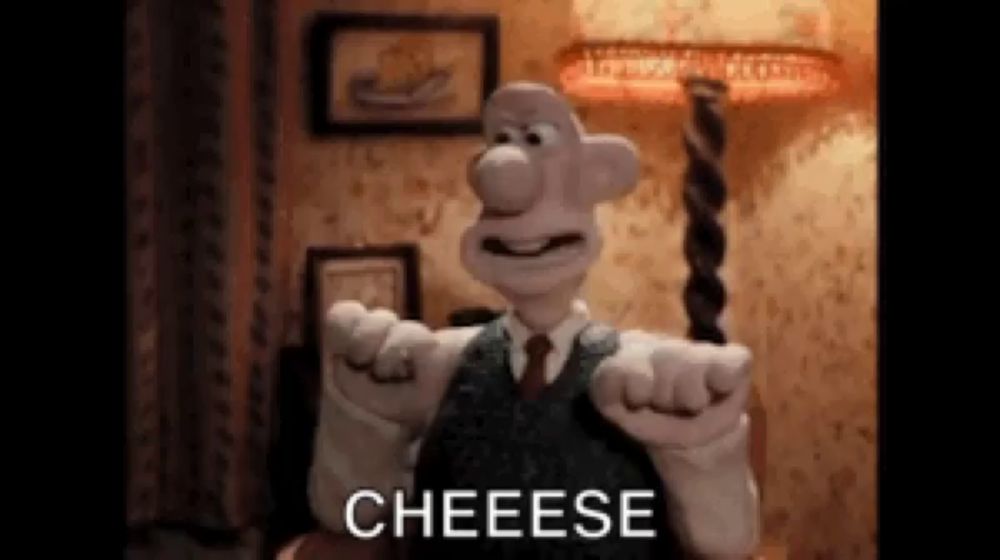 a cartoon character in a suit and tie is pointing at the camera and saying cheese .