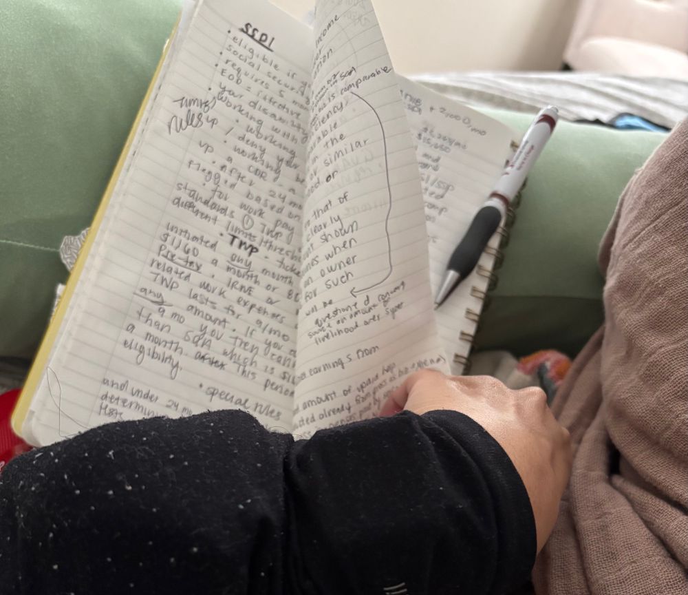 Picture of my notebook with writing on three sheets of paper back and front 