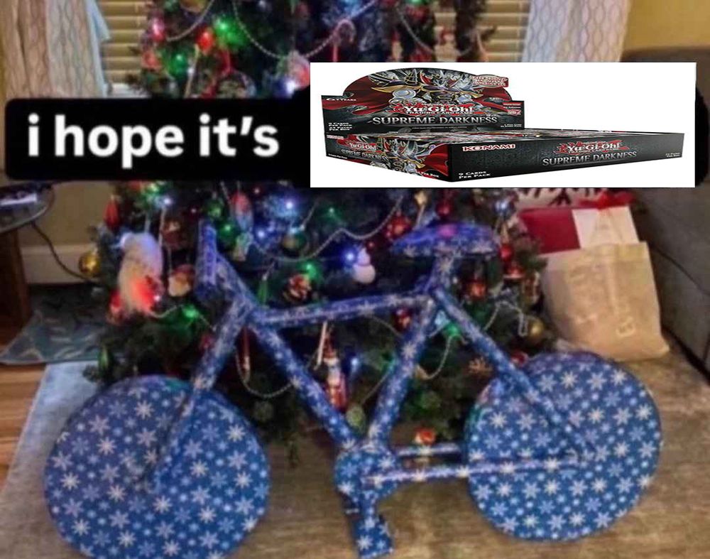 Bike wrapped in wrapping paper with caption "i hope it's" followed by a picture of the yugioh set Surpeme Darkness