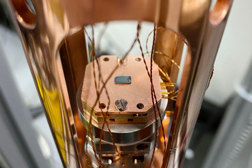 Close-up view of a copper-colored scientific instrument with intricate wiring details inside a laboratory setting.