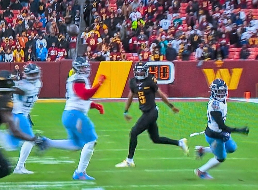 NFL game, Jayden Daniels completing a pass to Terry McLaurin after drawing the entire side of the defense to him on what looked like a QB run.