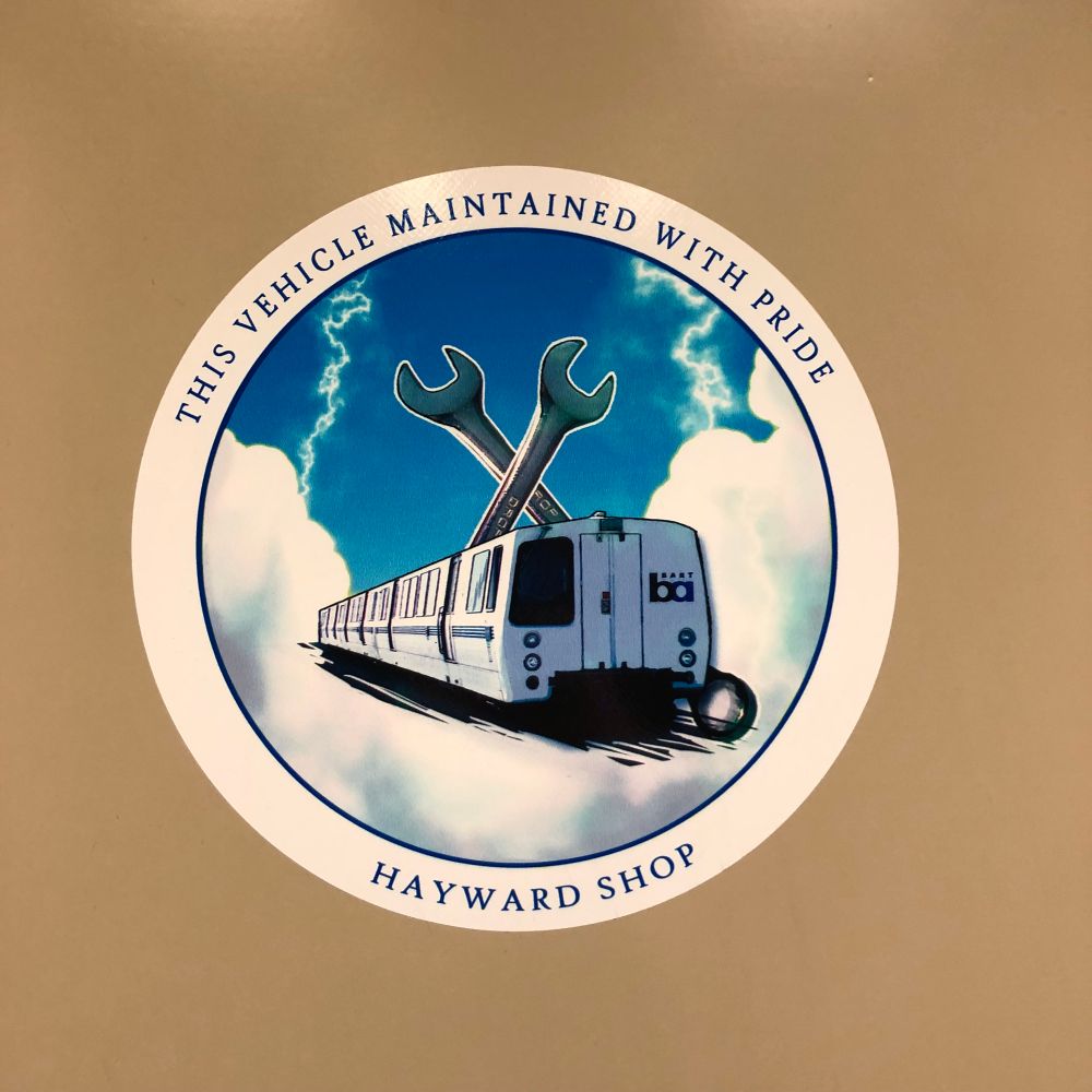 Roundel sticker depicting a BART train Andntwo wrenches. The roundel says: “This Vehicle Maintained With Pride – Hayward Shop”