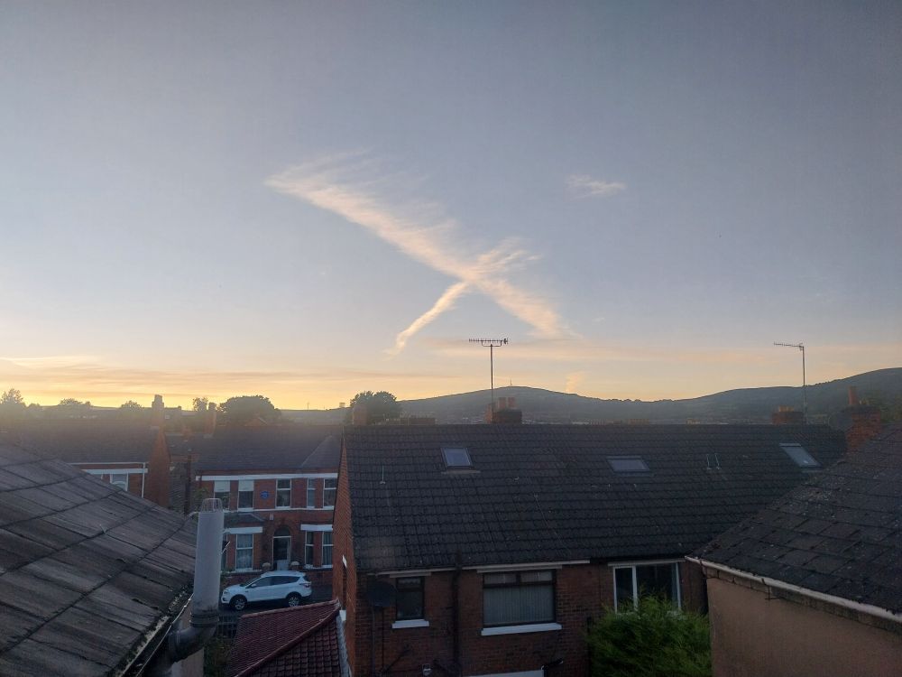 In a largely blue sky, two aircraft vapour trails have crossed to produce a large 'X'. On a blue background, I'm suggesting that it resembles the Scottish saltire. 