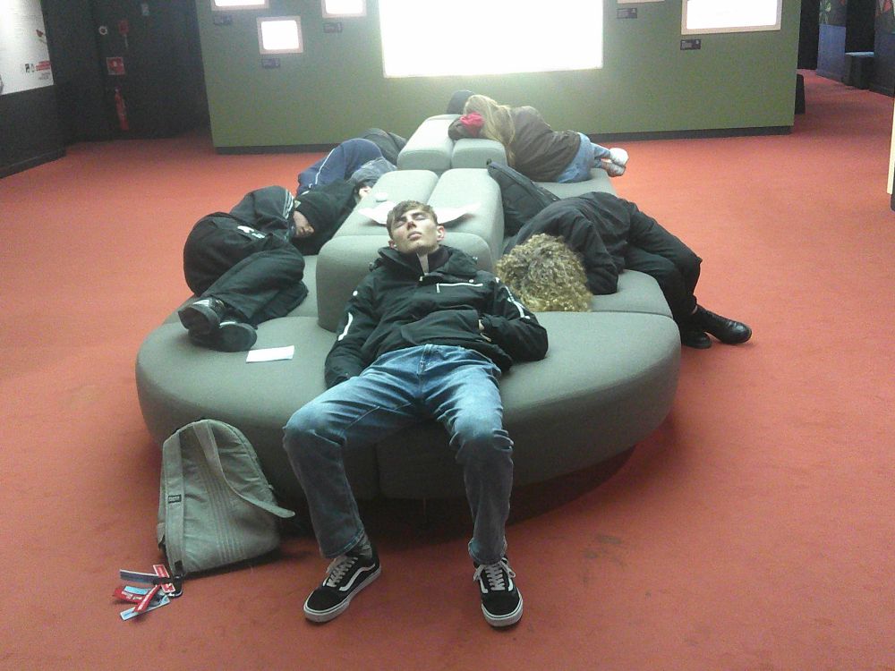 Sleeping students on a museum sofa