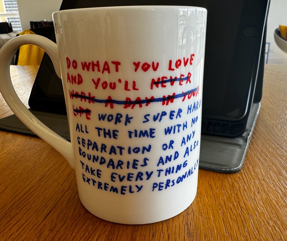 Coffee mug illustrated in hand written

DO WHAT YOU LOVE AND YOU'LL [then crossed out NEVER WORK A DAY IN YOUR LIFE ] (written in a different colour )-WORK SUPER HARD ALL THE TIME WITH NO SEPARATION OR ANY BOUNDARIES AND ALSO TAKE EVERYTHING EXTREMELY PERSONALLY
