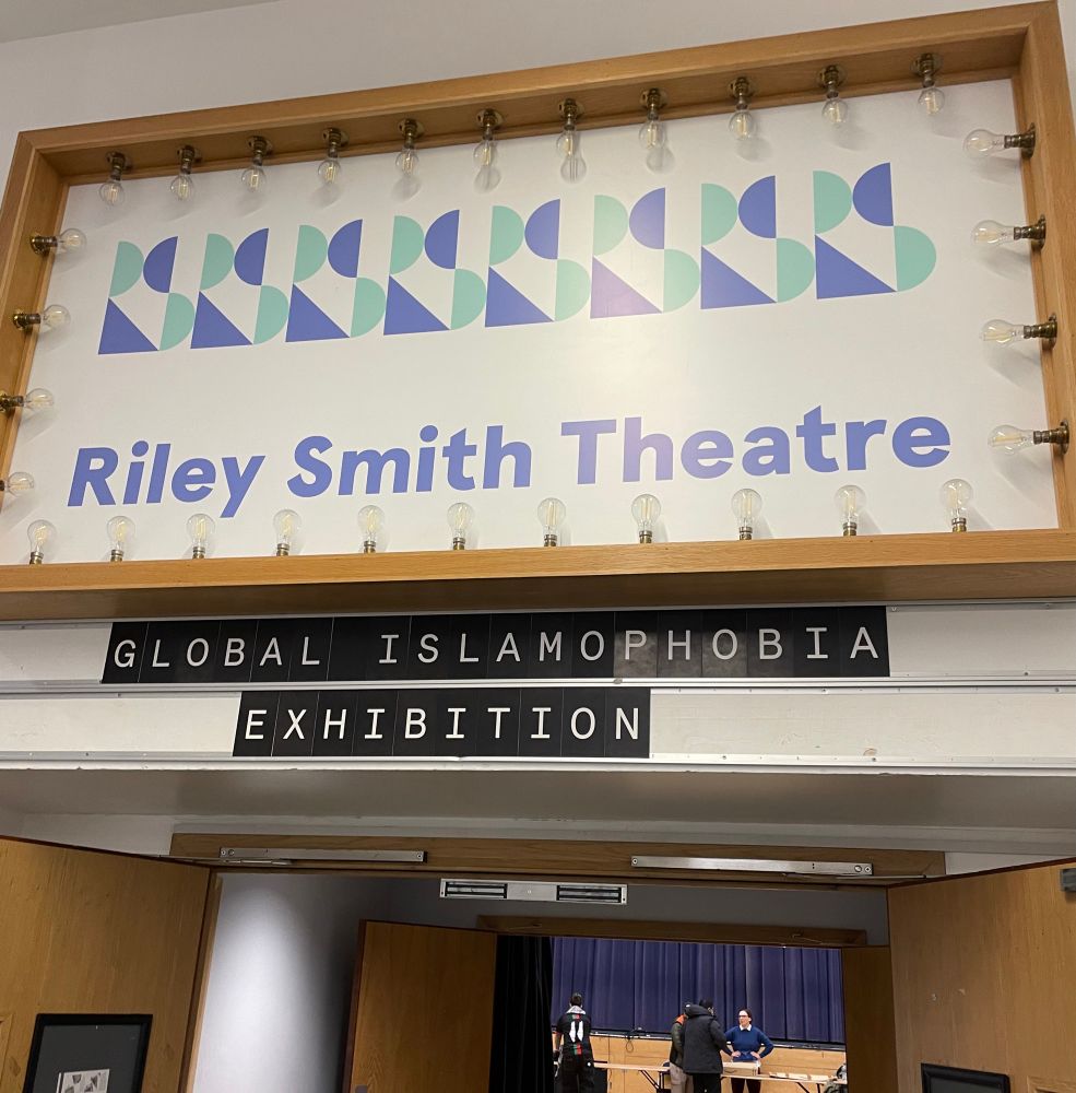 Photo of the doorway of a theatre space with sign reading “global Islamophobia exhibition”