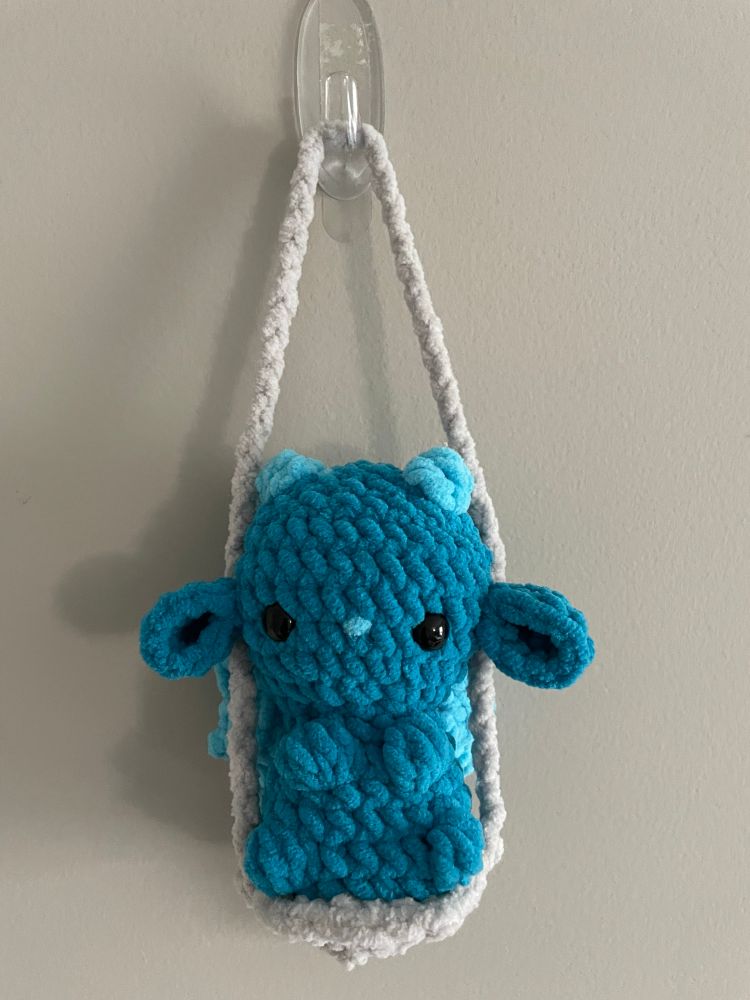 front view of small crochet dragon on swing