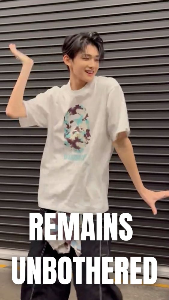 Jo from &Team. He's doing a dance and holding a hilarious carefree pose. The text reads REMAINS UNBOTHERED.