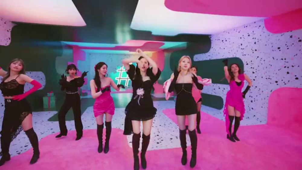 a group of women are dancing in a pink room