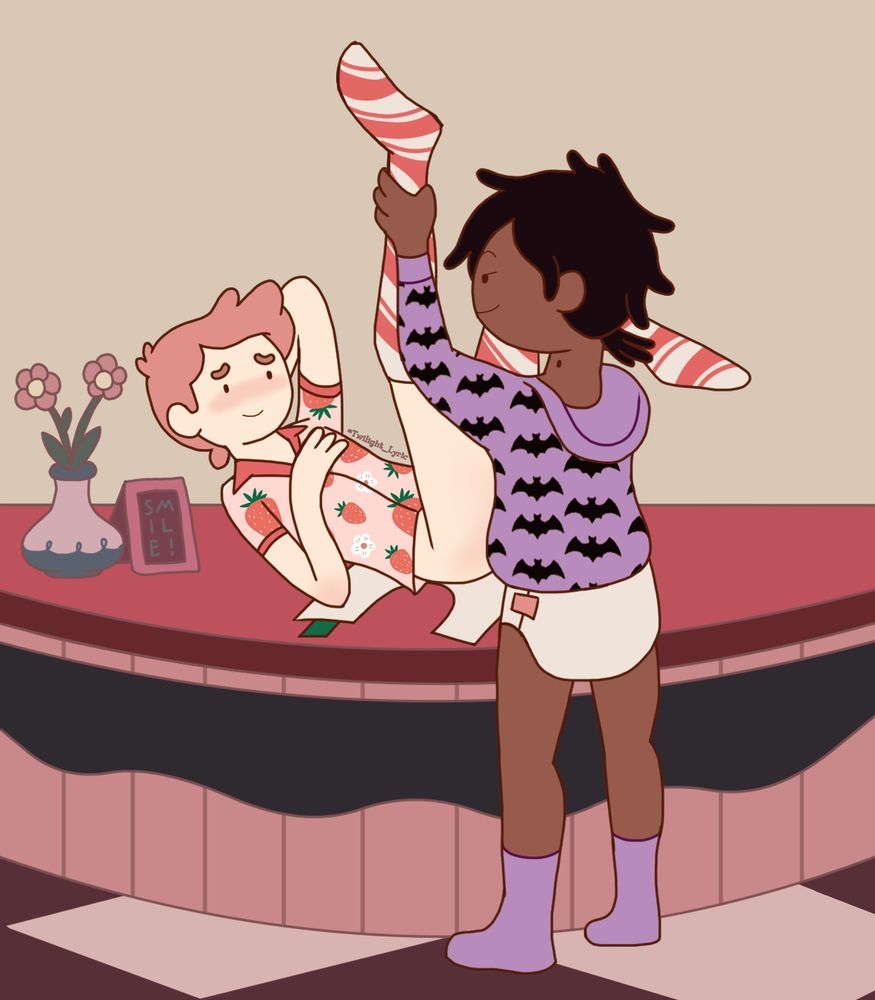 A drawing of two cartoon men. The one on the left is laying across the counter as the one on the right changes their diaper while standing. The left man has bubblegum pink hair and pale skin. He is wearing a pink shirt with a strawberry pattern and socks with white and red stripes like a candy cane. The right man has black hair and dark brown skin. He is wearing a hoodie with a bat pattern, purple socks, and a white diaper.
